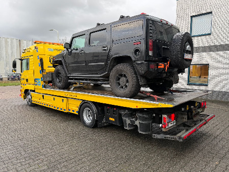 Personenwagen op een gele MAN-takelwagen